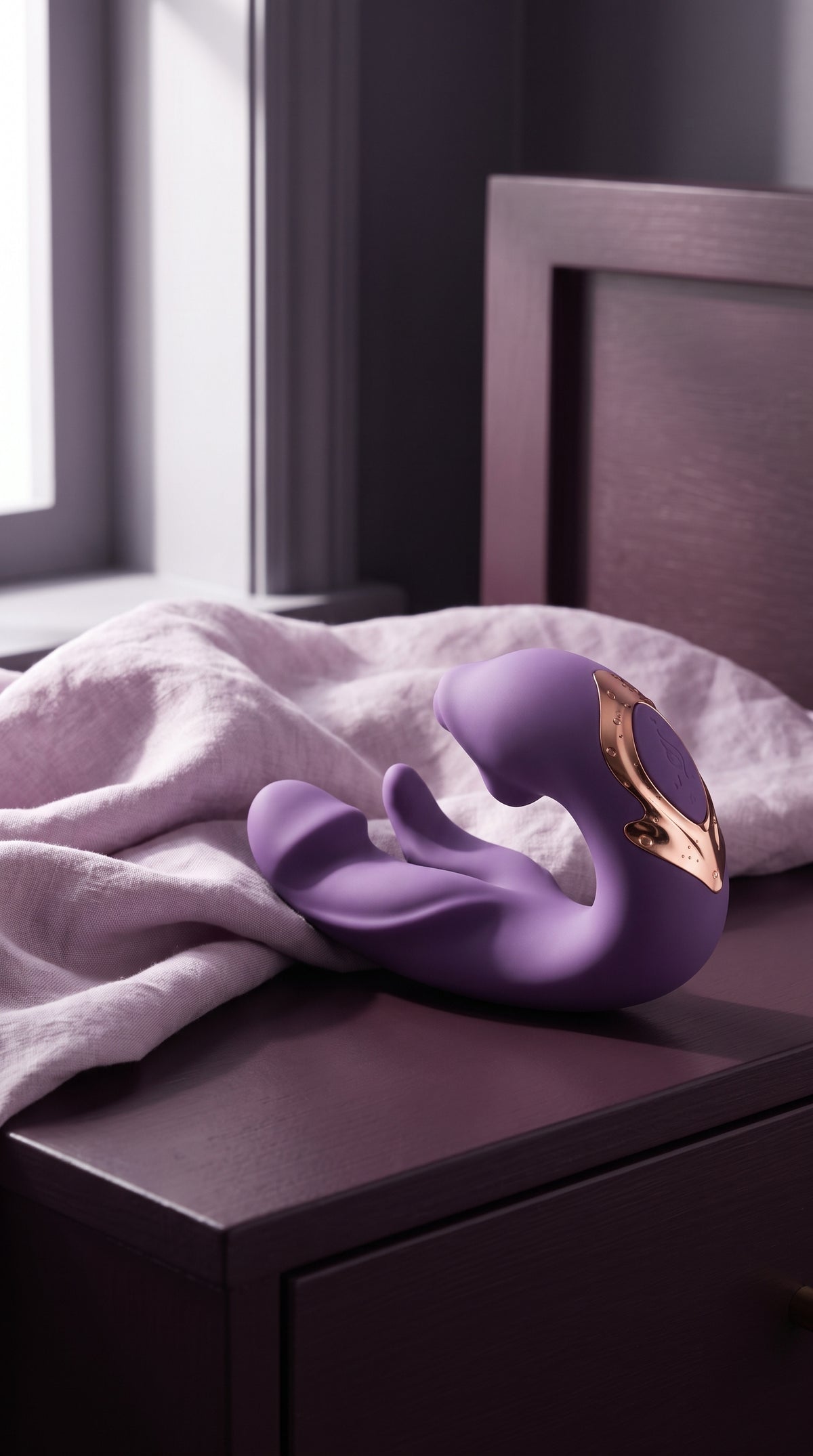 Purple ÉLAN beside lilac linen on a dark bedside table