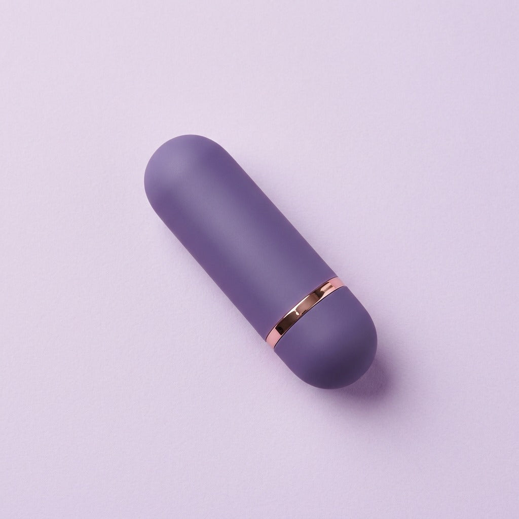 DOVIAR PETITE bullet vibrator in muted violet with a rose-gold band, on a lilac background