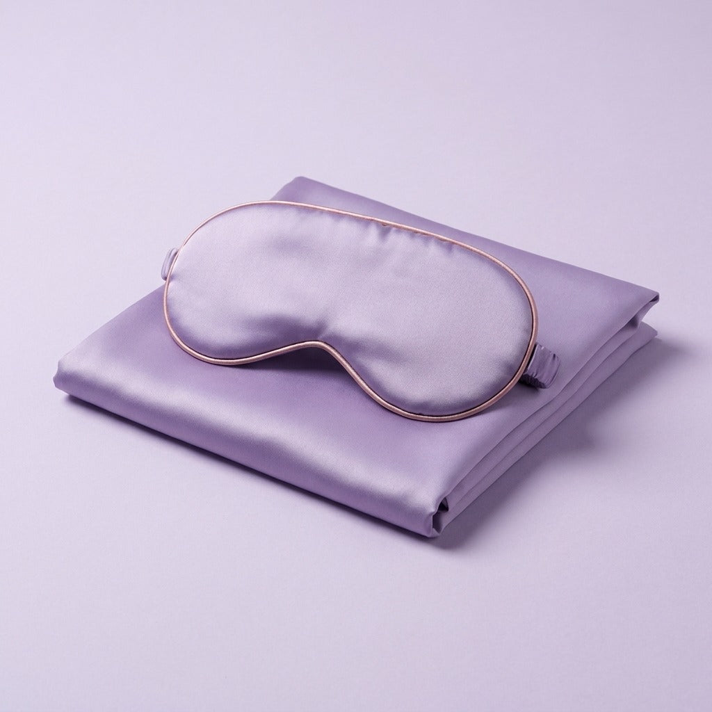 DOVIAR SOMMEIL lilac satin sleep mask resting on a matching folded pillowcase