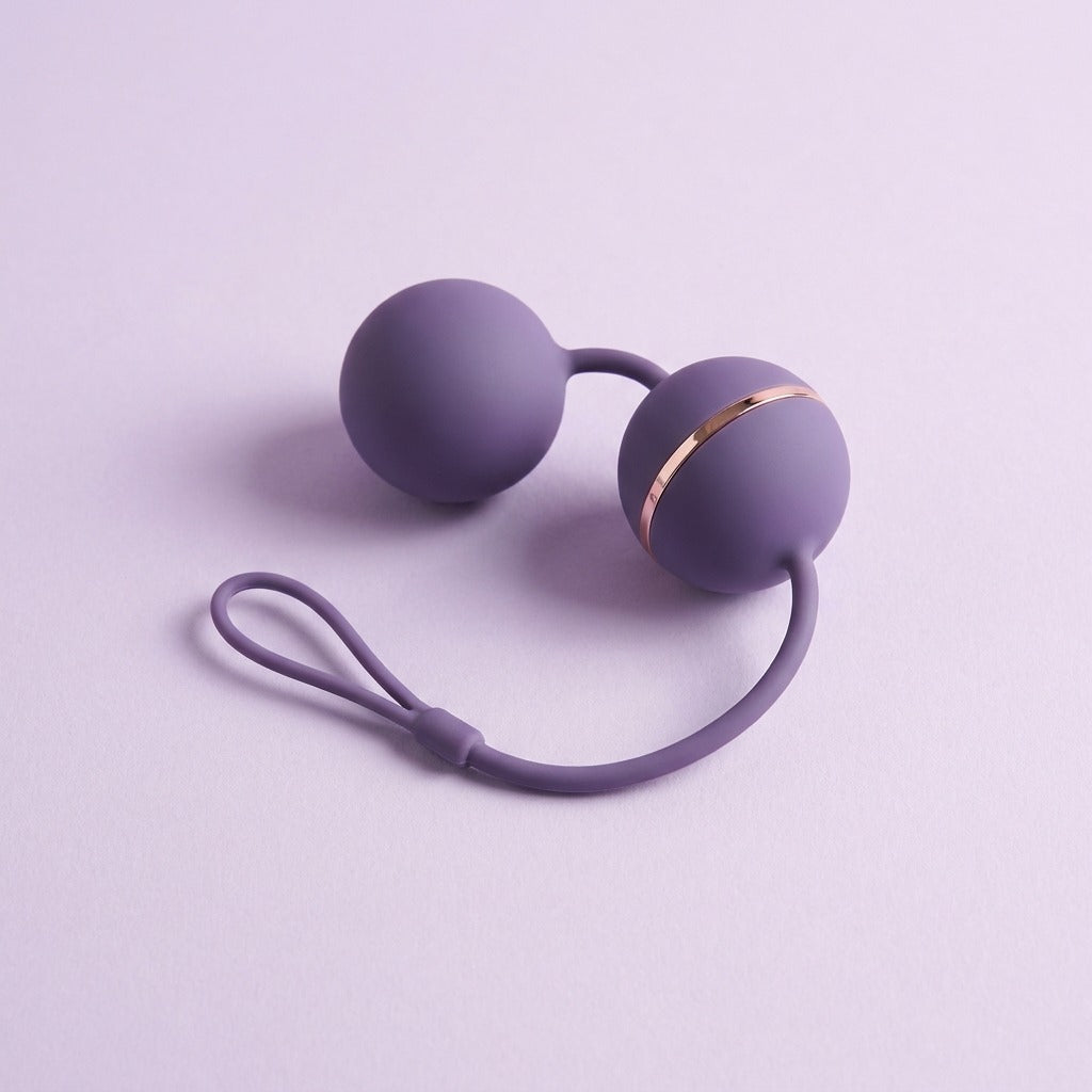 DOVIAR TONE weighted pleasure balls with a retrieval loop and rose-gold band, on a lilac background