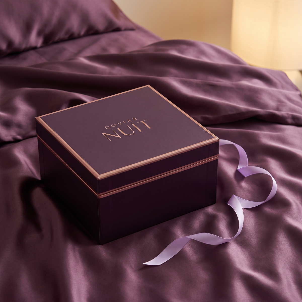DOVIAR NUIT evening gift box on plum satin bedsheets
